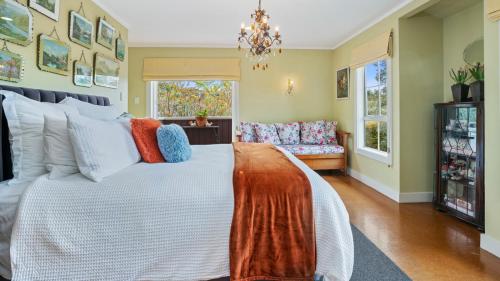 een slaapkamer met een groot bed en een bank bij A Ray of Sunshine - Manly Holiday Home in Whangaparaoa