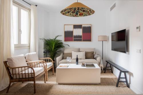 een woonkamer met een bank en een salontafel bij Tetuán 15 Boutique Apartments by Hommyhome in Sevilla