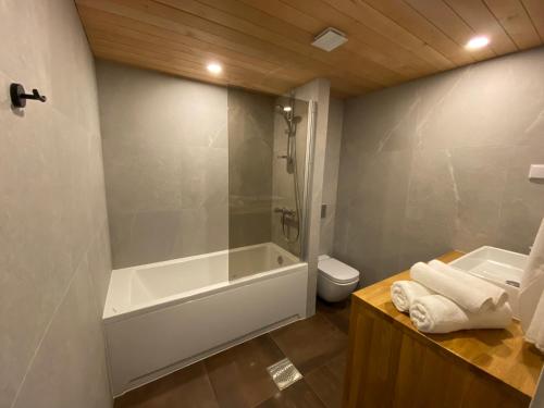 a bathroom with a tub and a toilet and a sink at Modern Smuuli apartment in Kuressaare