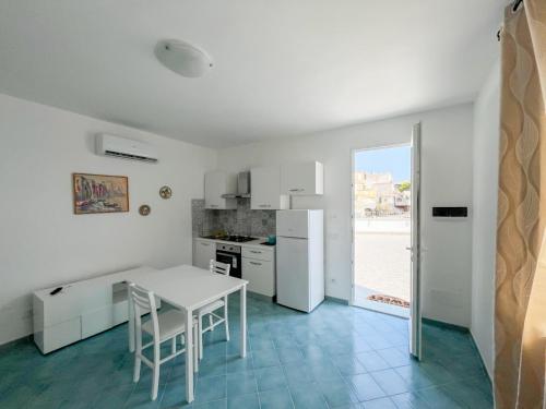 een keuken met een witte tafel en een witte koelkast bij Residence Terme Belliazzi- Isola d'Ischia in Ischia