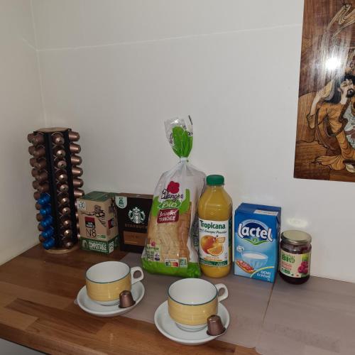een aanrecht met twee kopjes koffie en wat eten bij Chambre privée classée 2 étoiles avec serrure et non mitoyenne dans un appartement de 50 m2 dans une résidence cosy et Paris à proximité in Colombes