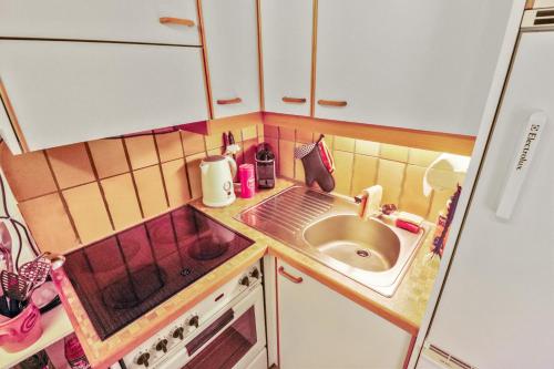 een kleine keuken met een wastafel en een aanrecht bij Superbe appartement avec parking couvert gratuit in Lens