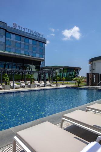 a swimming pool in front of a building at Hyatt Regency Trivandrum in Trivandrum