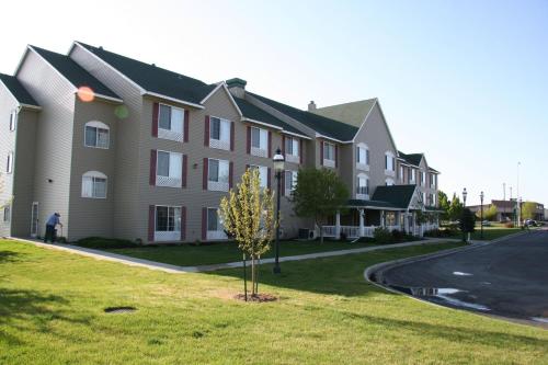 a large apartment building with a tree in the yard at Country Inn & Suites by Radisson, Greeley, CO in Greeley