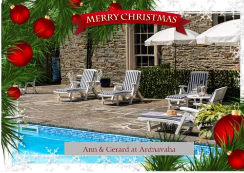 a merry christmas sign with chairs and a pool at Ardnavaha House - Poolside Cottages in Clonakilty