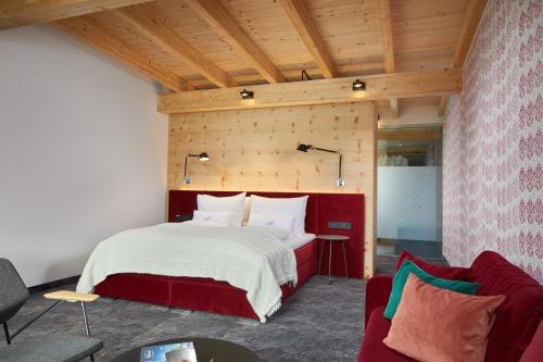 a bedroom with a large bed and a couch at HUBER's Boutiquehotel in Mayrhofen