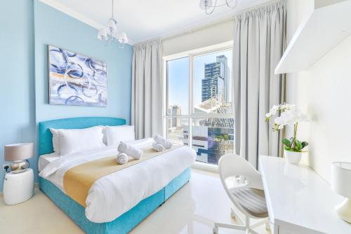 a blue and white bedroom with a bed and a desk at Dunya Tower · Downtown Luxury · 5 Min Walk To Dubai Mall! in Dubai