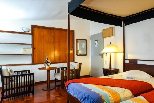 um quarto com uma cama, uma mesa e cadeiras em Residencial Colombo em Funchal