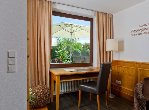 an office with a desk and a window with an umbrella at Hotel Heinzler am See in Immenstaad am Bodensee
