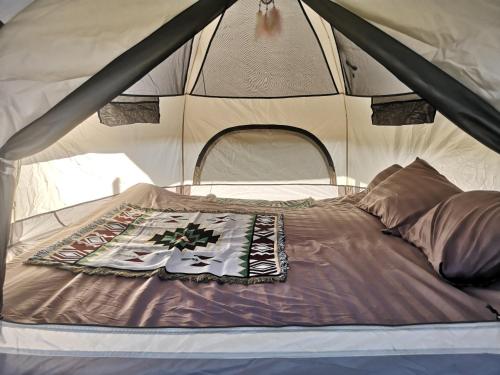 uma cama no meio de uma tenda em PANAKLUEA Cottage & Crafts - พนาเกลือ 