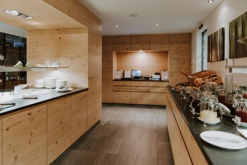 a kitchen with wooden walls and a long counter with dishes at HUBER's Boutiquehotel in Mayrhofen