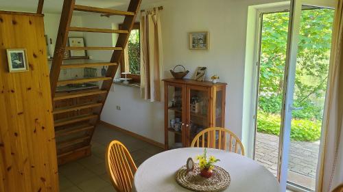 a dining room with a table and chairs and a staircase at Gut Hanerau, Eschenufer keine Monteure in Hanerau-Hademarschen