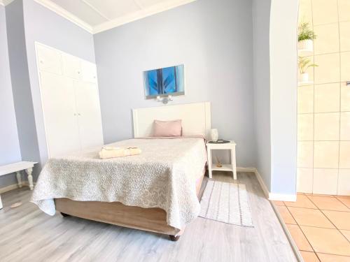 a white bedroom with a bed with a blanket at Barberton BnB in Barberton