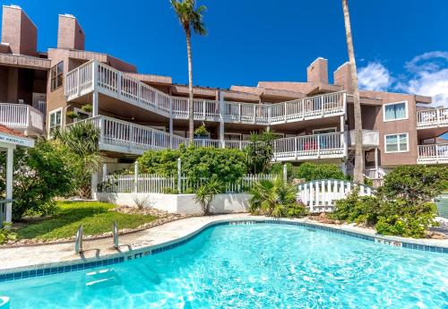 a swimming pool in front of a apartment building at Seaside Delight in Mustang Beach