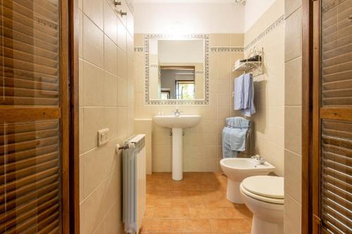 a bathroom with a sink and a toilet and a mirror at Celestina- Agriturismo La Valentina in Talamone