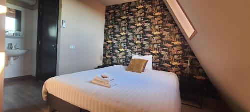 a small bedroom with a bed with a wall at Sientjes Boetiekhotel in Kerkdriel