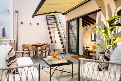 eine Terrasse mit Stühlen und Tischen sowie ein Esszimmer in der Unterkunft La Sillería de Arfe by Magno Apartments in Sevilla