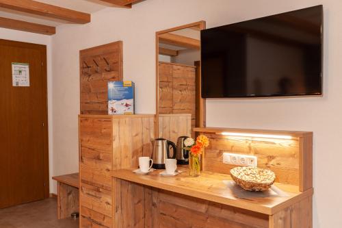 a room with a wooden counter with a television on a wall at Apart Harmonie in Kappl