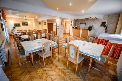 restauracja ze stołami i krzesłami w pokoju w obiekcie Willa Flora w mieście Krynica Zdrój