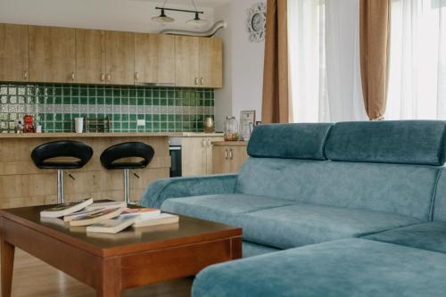 a living room with a blue couch and a coffee table at The K Guest House in Cluj-Napoca