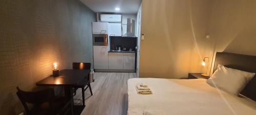 a hotel room with a bed and a desk and a kitchen at Sientjes Boetiekhotel in Kerkdriel