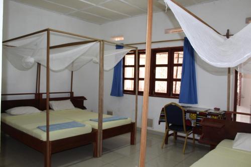 a bedroom with two bunk beds and a desk at Centre Lucien Botovasoa in Diego Suarez