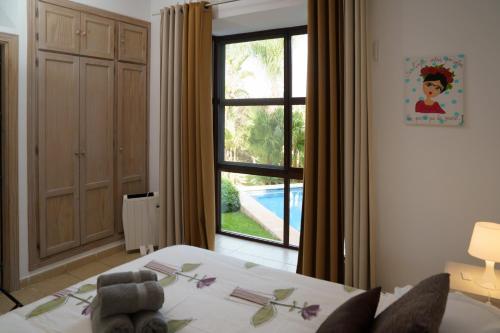 een slaapkamer met een bed en een raam met een zwembad bij TESS Villa Rio Nilo in Alhaurín de la Torre