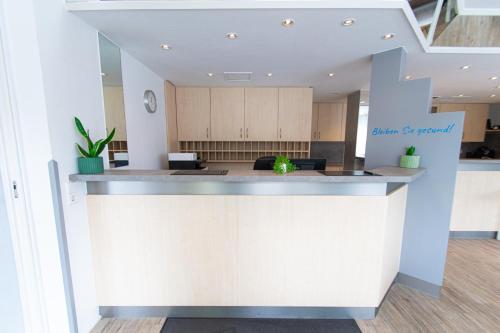 a kitchen with a white island in a room at Taste Smart Hotel Backnang in Backnang