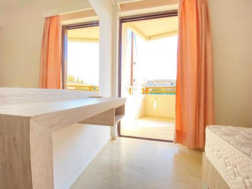 Habitación con mesa y ventana grande. en Domenica Apartments, en Rethymno