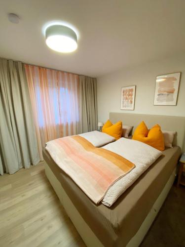 a bedroom with a large bed with orange pillows at Christianes Apartment - Ebstorf in Ebstorf