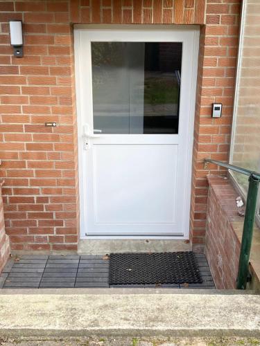 a white door on a brick building with a window at Christianes Apartment - Ebstorf in Ebstorf