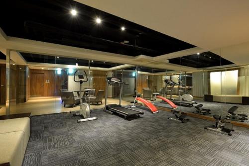 a gym with several treadmills and machines in a room at Hotel Cloud in Taipei