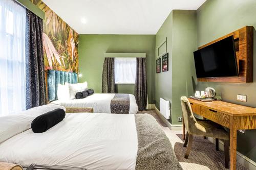 a hotel room with two beds and a desk at Inn on the Lake by Innkeeper's Collection in Godalming