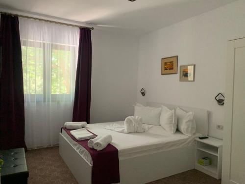 a bedroom with a bed with towels on it at Casa Chriss in Eforie Sud