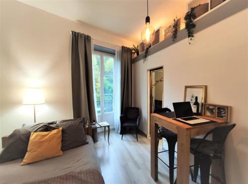 une chambre avec un lit et un bureau avec un ordinateur portable dans l'établissement Charmant studio proche du centre et des thermes, à Aix-les-Bains