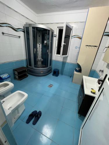 a blue bathroom with a sink and a mirror at Luxury Rooftop Apartament in Fier