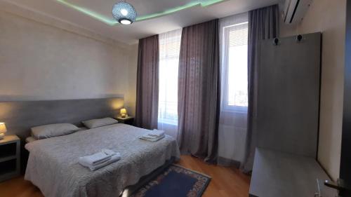a bedroom with a bed and a large window at Makos Guest House in Kutaisi