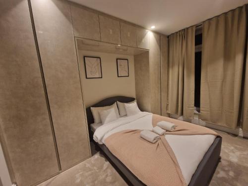 Schlafzimmer mit einem Bett mit weißer Bettwäsche und Kissen in der Unterkunft Spacious 2 BR with Balcony in Hendon in Colindale
