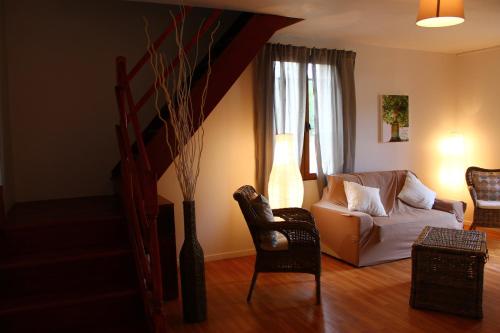 a living room with a couch and a chair at Gites de Coulonge in Coulonges-Ardennes