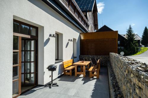 a patio with a wooden table and chairs on a building at Wellness & Spa Pila Kvilda AP 2 01 a AP 3 07 in Kvilda