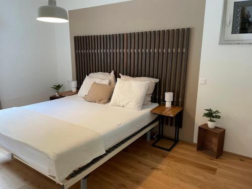 um quarto com uma cama grande e uma cabeceira em madeira em Ferienwohnung Edelbach Deluxe em Sattendorf