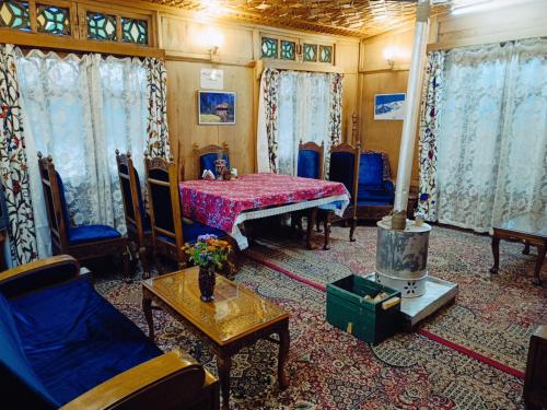 uma sala de estar com um sofá e uma mesa em Houseboat New Jeddah em Srinagar