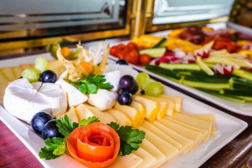 a plate of cheese and vegetables on a table at River hotel KÖNIGSTEIN in Prague