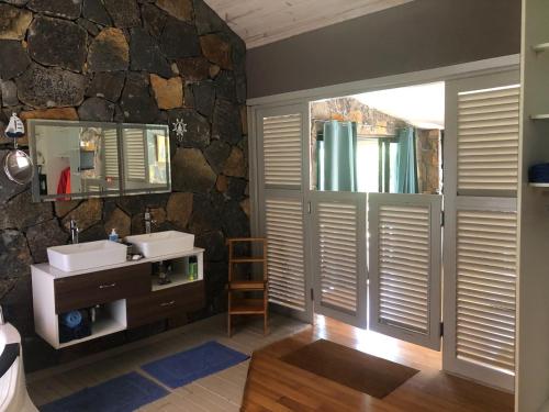 a bathroom with a sink and a stone wall at Super villa familiale in Pointe aux Piments