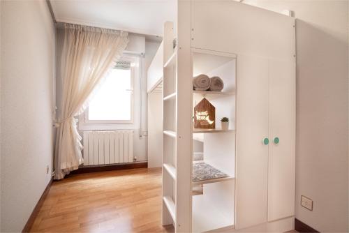 un armadietto bianco in una stanza con finestra di La casita de las campanas a Cenicero
