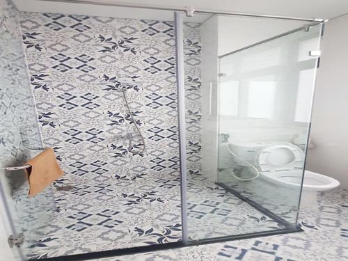 y baño con ducha de cristal y aseo. en Hotel Phúc Lâm Grand World, en Phu Quoc