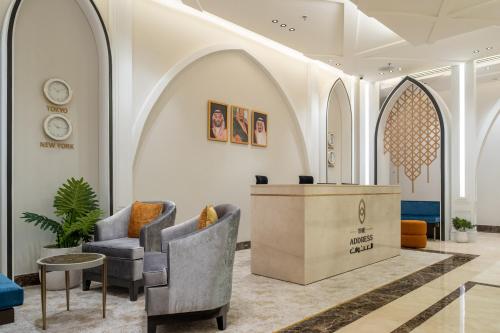 um átrio com duas cadeiras e uma recepção em العنوان للشقق المخدومة-The Address Residence em Al Khobar