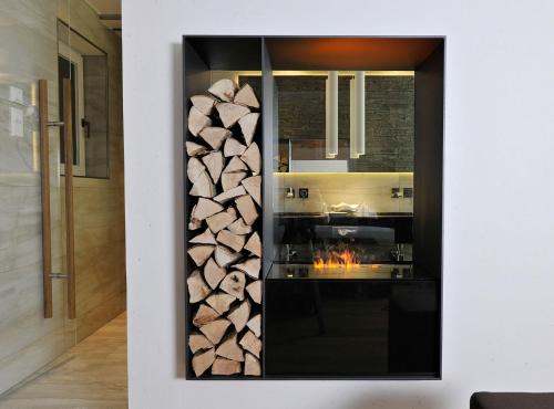 a fireplace in a kitchen with a pile of fire wood at Hotel Heinzler am See in Immenstaad am Bodensee