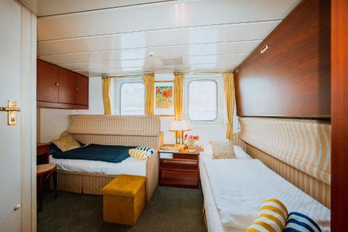 a small bedroom with two beds in a boat at River hotel KÖNIGSTEIN in Prague