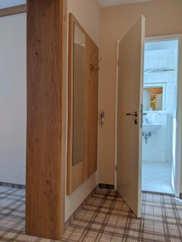 a bathroom with a door leading to a sink at Hotel Germania in Bad Wörishofen